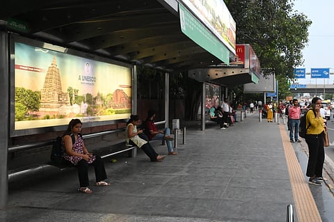 Passengers wait for a DTC bus at the ITO Bus stop during the strike called by DTC employees demanding higher wages and better medical and social security benefits, in New Delhi on Thursday.