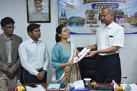 APNRT president Ravi Kumar Vemuru and OMCAP MD Ganesh Kumar hand over appointment letters to women selected for healthcare jobs in Germany.