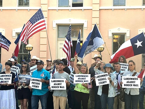 Landowners and other supporters hold signs against the Trump administration's plans to build a border wall and other infrastructure in Texas' remote Big Bend region, Monday, Sept. 14, 2026, in Marfa, Texas
