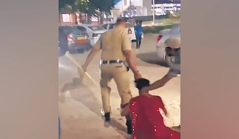Screengrab of the home guard dragging the woman by her hair at Hafeezpet railway station in Hyderabad on Friday.