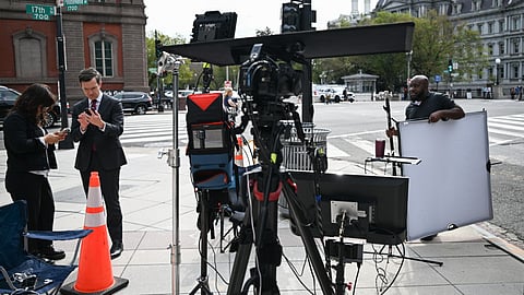 MS NOW White House Correspondent Vaughn Hillyard (2L) and MS NOW production crew members set up for a live shot on a street corner near the White House in Washington, DC, on September 21, 2026.