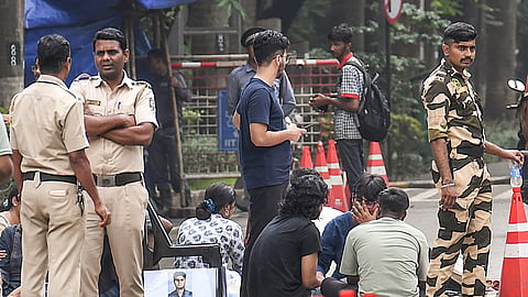 Security personnel stand guard as students stage a protest following the death of a 22-year-old Indian Institute of Technology (IIT) Bombay student, who died by suicide in his hostel room after he was allegedly caught using a mobile phone during an examination, at IIT Bombay, in Mumbai, Maharashtra, Saturday, Sept. 19, 2026.