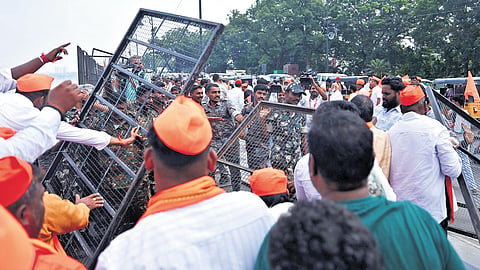 BGUS members remove barricades along the Hussainsagar as police forces look on at Tank Bund in Hyderabad on Monday.
