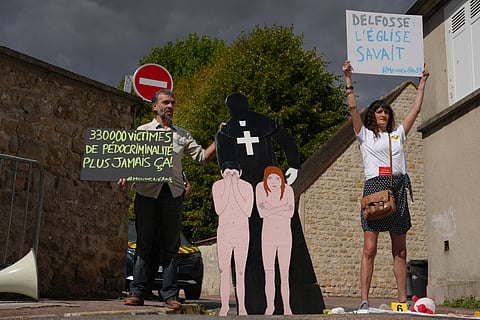 Activists fighting child abuse stage a protest near the home of a former Catholic priest suspected of sexually assaulting dozens of children, in Etrechy, outside Paris, Wednesday, Sept 16, 2026
