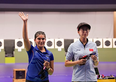 India's Esha Singh (L) greets after securing a silver medal during the women's 25m pistol event