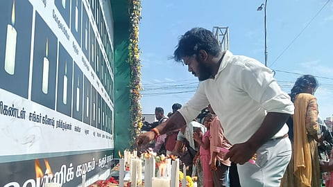 Family members of the stampede victims light candles in memory of their loved ones near Karur bus stand on Sunday.