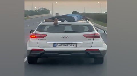 Screenshot of the cop clinging onto the roof of smugglers’ car
