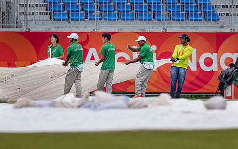 The groundstaff bring the covers in as rain falls down at the Korogi Athletics Park on a matchday
