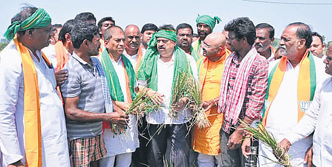 State BJP president N Ramchander Rao interacts with farmers at Chinna Madharam village in Kanagal mandal of Nalgonda district on Wednesday.