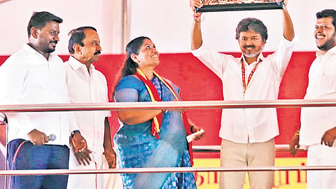 Chief Minister C Joseph Vijay holding a portrait of himself and MGR during the campaign in Dharapuram on Wednesday, Sept 30, 2026.