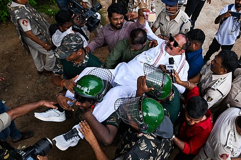 Congress MLA Tara Prasad Bahinipati being taken into a police van during the INDIA bloc protest demonstration against MMDR Amendment Act and SIR, at Mahatma Gandhi Marg in Bhubaneswar on Tuesday.