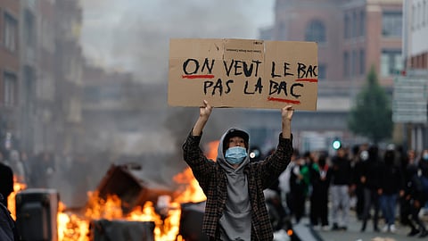 A student holds a board reading, "We want the BAC (High School Diploma), not the BAC (Anti-criminality units)" during a protest to demand more resources at school, in Lille, France, Thursday, Oct. 1, 2026