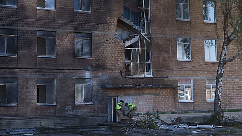 Police officers carry an unexploded warhead from a Shahed drone out of a school damaged by a Russian strike on Kyiv, Ukraine, Thursday, Oct. 1, 2026.