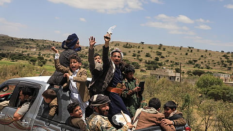 Yemeni civilians celebrate while riding in the back of a pickup truck in the Bani Matar district, Yemen, Saturday, Sept. 12, 2026, as they follow a convoy carrying Houthi prisoners freed in Mokha on its way to Sanaa following the Houthi takeover of the southern Red Sea port city.