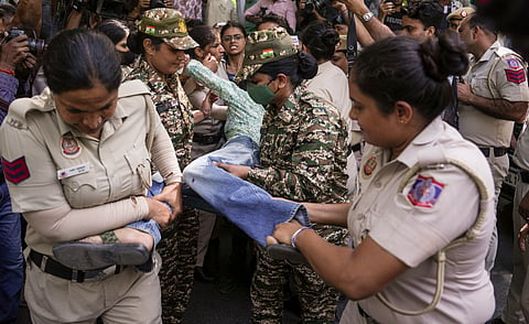 Police personnel detain an activist during a protest organized by various student bodies, including AISA, SFI, and NSUI, demanding the resignation of Chief Election Commissioner (CEC) Gyanesh Kumar over alleged irregularities in electoral rolls, near Jantar Mantar, in New Delhi, Saturday, Oct. 3, 2026.