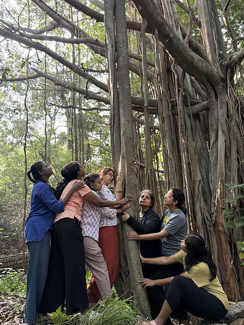A group of activists hugs a tree to express concern about the plan to fell 1,128 trees for the Hebbal Short Tunnel Project in Bengaluru on Sunday