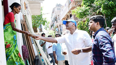 Health secretary Darez Ahamed distributes dengue awareness pamphlets to a resident of East Namasivayapuram in Teynampet Zone on Sunday.