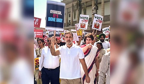 In this screengrab from a video posted on Oct. 6, 2026, Leader of Opposition in the Lok Sabha Rahul Gandhi holds a placard reading 'Gyanesh, It's Done Bro!' alongside Congress leader Priyanka Gandhi Vadra during an INDIA bloc protest march from Parliament toward the Election Commission office, demanding the resignation of Chief Election Commissioner Gyanesh Kumar, in New Delhi.