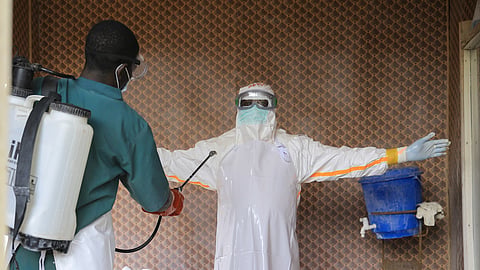 A healthcare worker in protective clothing is disinfected by a colleague inside a treatment center for Ebola patients in Beni, North Kivu province, eastern Congo, Saturday, Sept. 26, 2026.