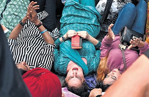 Congress MP Priyanka Gandhi Vadra and other INDIA bloc members lie on the road with a copy of the Constitution in New Delhi on Wednesday