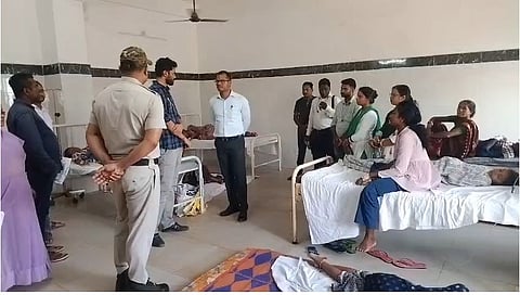 Collector Hemakanta Say interacts with doctors treating the sick students.