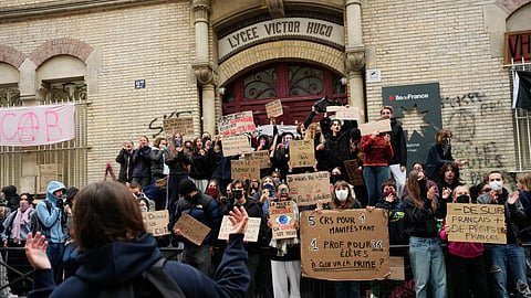 Students stand in front of a blockaded high school as they protest against under-resourced schools in Paris, Friday, Oct. 9, 2026.
