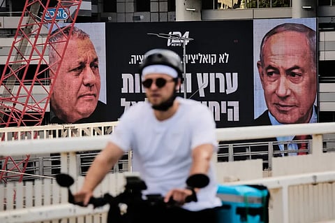 A man rides bicycle past a television channel advertisement featuring Israeli Prime Minister Benjamin Netanyahu, right, and his main rival, opposition candidate Gadi Eisenkot, ahead of Israel’s general election, in Ramat Gan, Israel, Wednesday, Sept. 23, 2026.