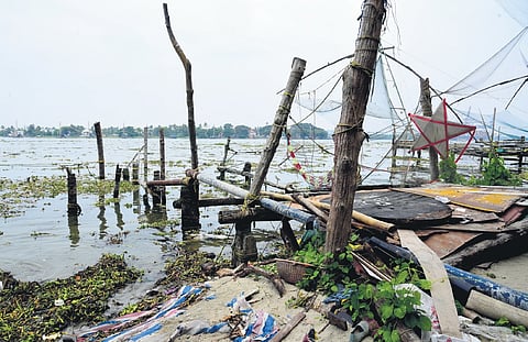 (L) Damaged Chinese fishing net lies abandoned in Fort Kochi, while logs of wood brought for its repair rot nearby due to official apathy