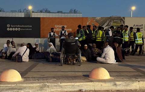 People gather outside a metro station on the road to King Khalid International Airport in Riyadh, Saudi Arabia, Saturday, Oct. 10, 2026.