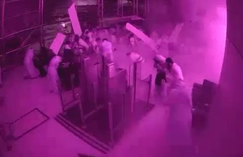 This image from CCTV video released by Saudi Arabia's Media Ministry shows passengers taking cover as flames and smoke fill part of King Khalid International Airport in Riyadh, Saudi Arabia, during what authorities described as a strike at the airport on Saturday, Oct. 10, 2026.
