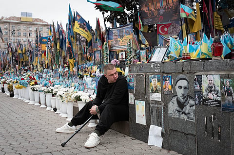 A veteran pays his respects at a makeshift memorial to Ukrainian soldiers killed in the war with Russia, on Independence Square in Kyiv, Ukraine, Monday, Oct. 12, 2026.