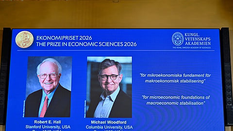 Portraits of Robert E. Hall and Michael Woodford are shown on the screen as they are announced as the laureates of the Sveriges Riksbank Prize in Economic Sciences in Memory of Alfred Nobel at the Royal Swedish Academy of Sciences in Stockholm, Sweden, Monday, Oct. 12, 2026.