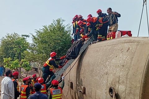 In this photo released by the Rescue 1122 Emergency Department, rescue workers recover an injured person from a derailed coach on the outskirts of Multan, in central Pakistan, Tuesday, Oct. 13, 2026.