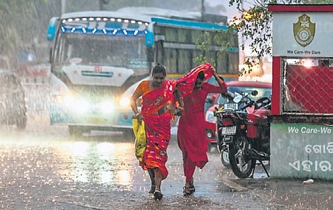 Women run for cover amid rain, at Rasulgarh in Bhubaneswar on Tuesday evening | DEBADATTA MALLICK