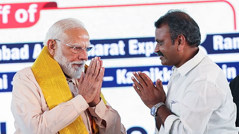 Prime Minister Narendra Modi and Union Minister of State L Murugan greet each other.