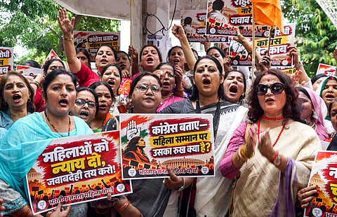 BJP Mahila Morcha activists raise slogans during a protest under the banner of 'Nari Shakti Hunkar' against Congress MP and former JNU professor Angomcha Bimol Akoijam over allegations of sexual harassment, in Varanasi, Uttar Pradesh, Monday, Oct. 12, 2026.