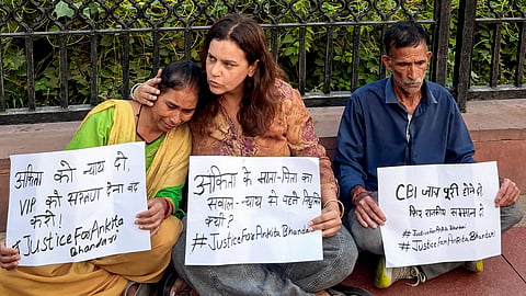 Activist Yogita Bhayana, centre, with the parents of the deceased victim Ankita Bhandari stage a sit-in protest at India Gate demanding justice for their daughter, in New Delhi, Wednesday, Oct. 14, 2026.