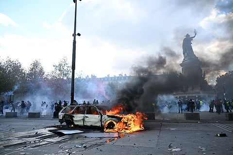 A car burns at Place de La Republique during a protest against rising living costs in Paris, Saturday, Oct. 17, 2026.