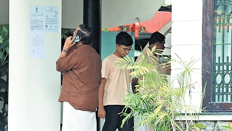 CPM leader Kadakampally Surendran looks at the ED summons pasted at Leader of Opposition Pinarayi Vijayan’s residence in Thiruvananthapuram
