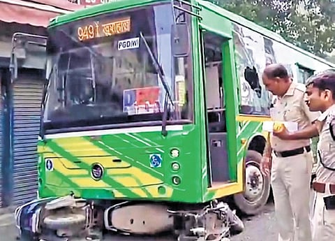 Police personnel inspect site after a DTC bus hit a scooter at Anand Parbat