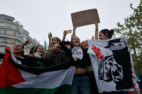 Students chant during a protest against under-resourced schools in Rennes, France, Tuesday, Oct. 13, 2026. The placard reads: "resist to exist."
