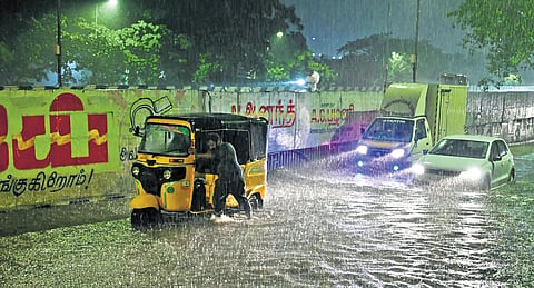 A driver pushing an autorickshaw through a waterlogged road in Perambur on Saturday night.