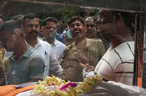 Family member of a victim mourns during the handover of mortal remains of victims to their family members following a stampede at Chorbagan Sarbojanin Durga Puja pandal, in Kolkata, Sunday, Oct. 18, 2026. Nineteen people died, and 25 others were injured in the stampede following a crowd surge amid rain on Saturday evening.