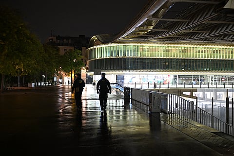 Policemen patrol during an overnight curfew in Paris, Tuesday, Oct. 20, 2026.