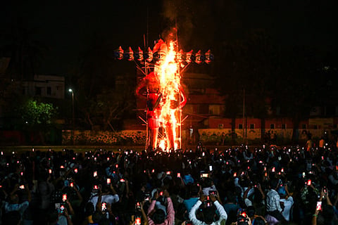 People watch an effigy of Demon King Ravana being burnt at Ravana Podi Ground at Nayapalli in Bhubaneswar on Wednesday.