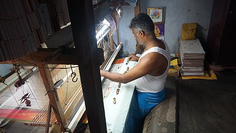 Handloom weaver Siva weaving a silk saree standing inside a 4-foot-deep pit loom.