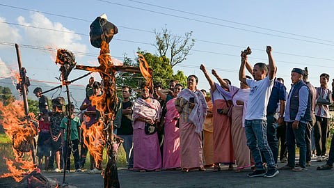 Flames and smoke billow after protestors burn effigies during a strike to protest against the killing of three Meiteis by suspected militants in Imphal, Wednesday, Oct. 21, 2026.