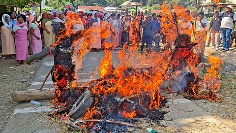 Protesters burn effigies of political leaders during a protest against the killing of three civilians, in Imphal East district, Manipur, Tuesday, Oct. 20, 2026.