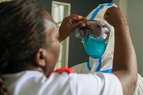 A health worker helps a colleague to put on a Personal Protective Equipment (PPE) in a room at an Ebola isolation facility at The Nairobi Hospital, Kenya, Wednesday, Oct. 7, 2026.