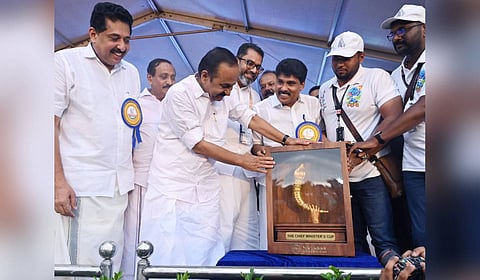 Chief Minister VD Satheesan admiring the Champions Trophy of the 68th Kerala State School Sports Meet at the NIT Calicut campus on Sunday evening when the trophy was brought to the main venue ahead of the grand inauguration of the state's premier school athletic spectacle.